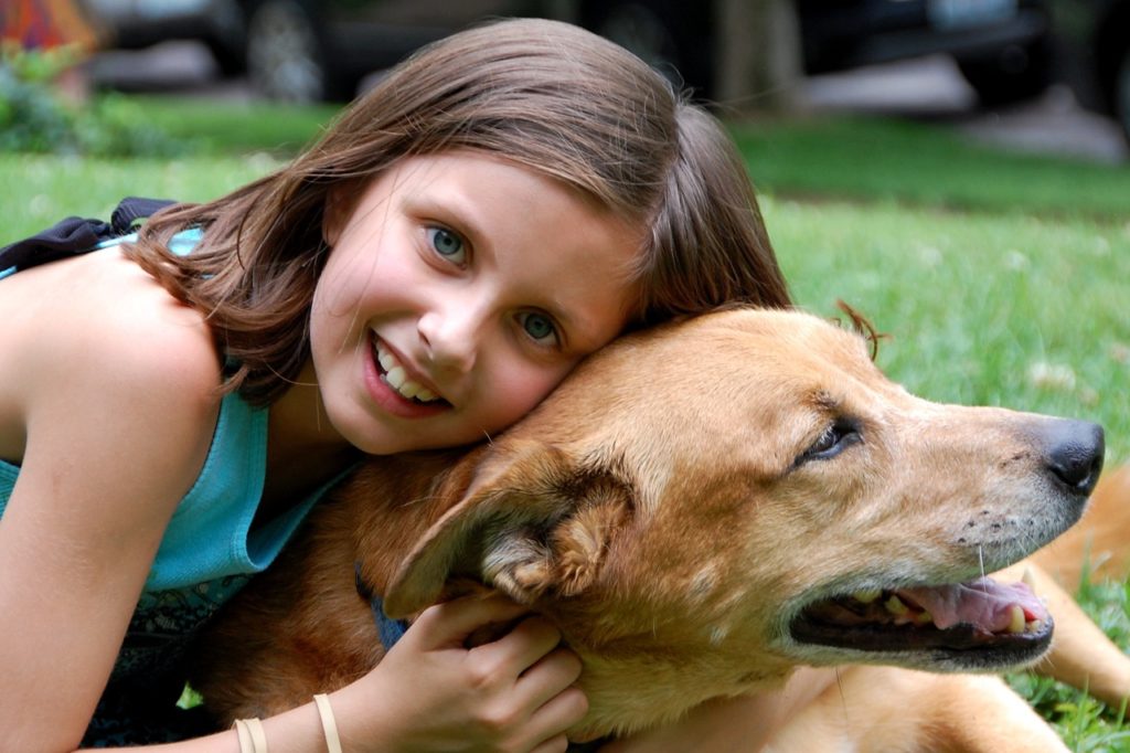 Niña encima de un perro